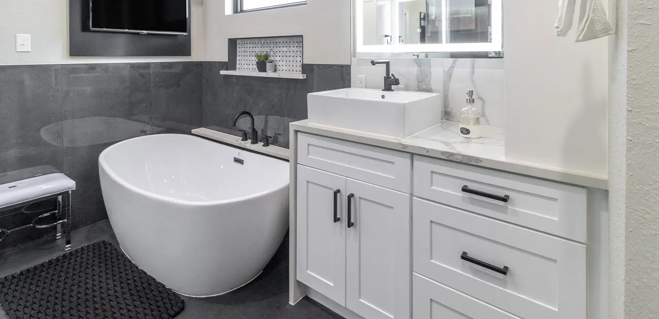 Updated full bath with marble flooring, vessel sink marble vanity, and standalone bath