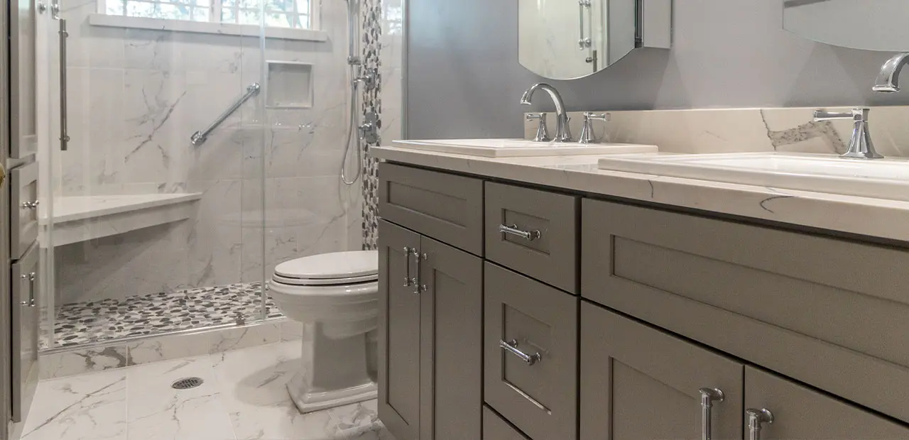 Modern updated bathroom with open floorplan, taupe double sink vanity, marble flooring, and black and white tiles
