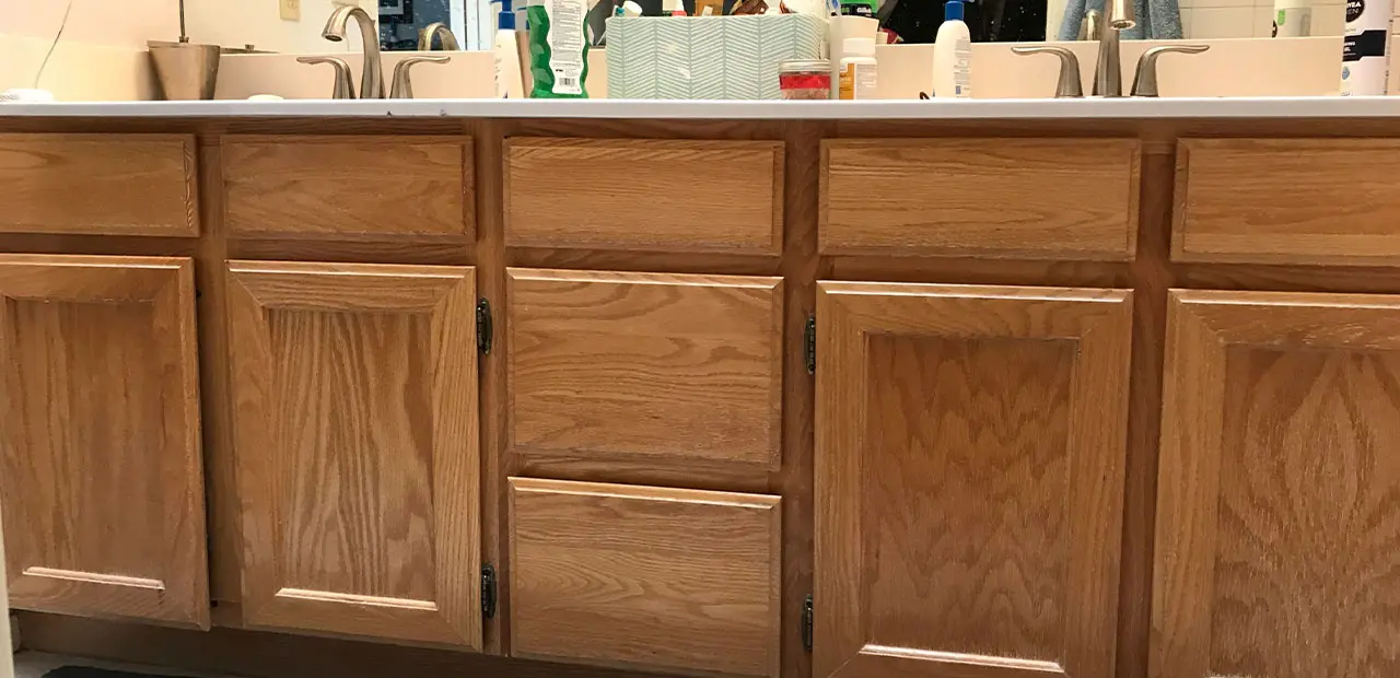 Builder-grade orange-toned wood double sink vanity