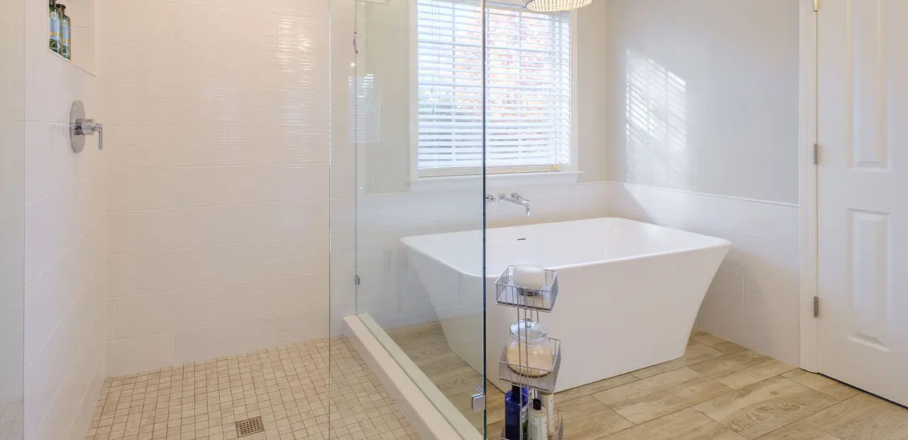 Updated white bathroom with freestanding bath and beige floor
